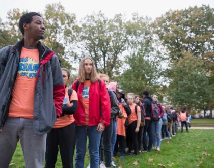 A line of students wearing shirts that say 