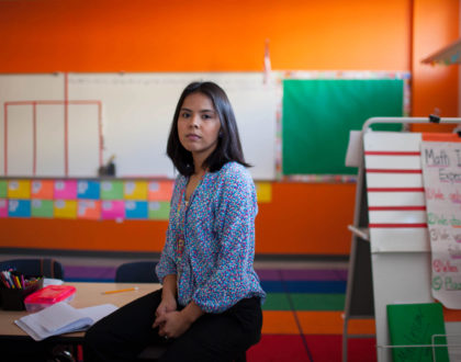 KIPP Esperanza teacher Maria Rocha in a classroom with orange walls