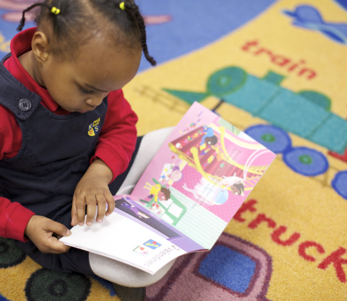 Kindergarten student reading a picture book
