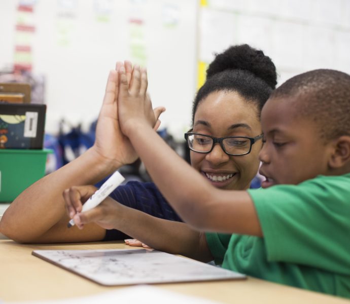 KIPP teacher high-fiving a student