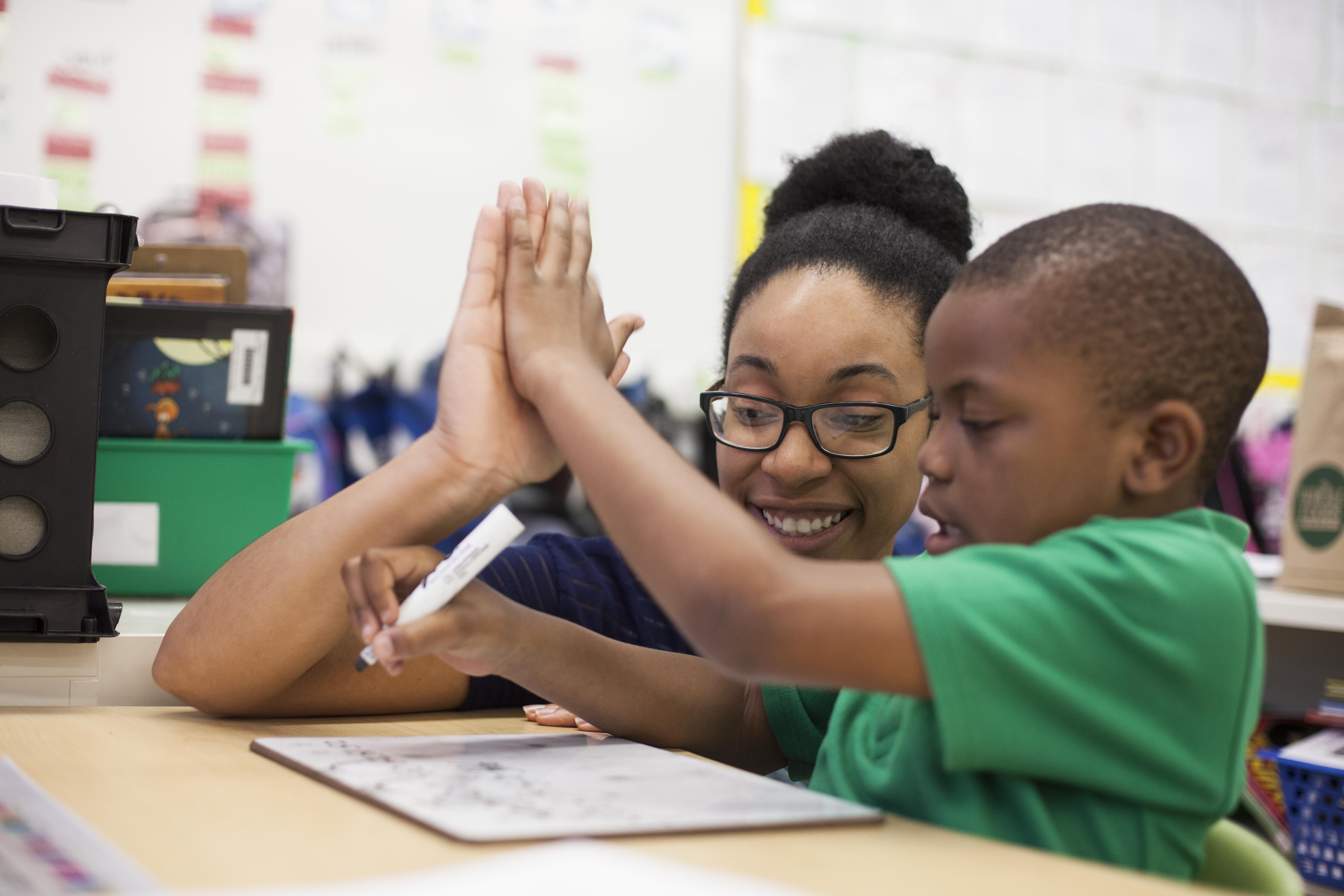 KIPP teacher high-fiving a student