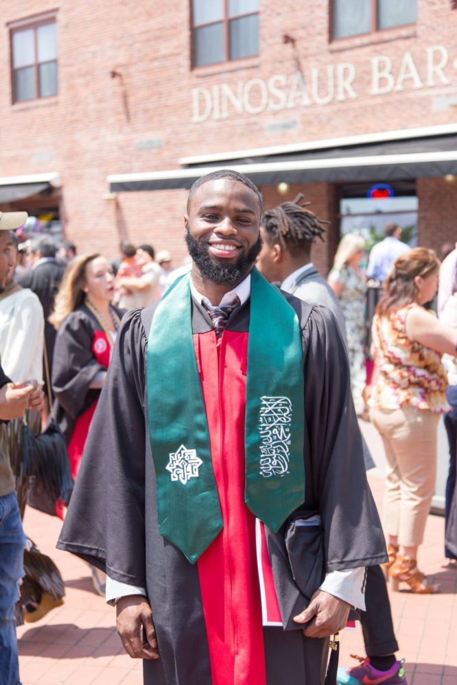 KIPP TEAM Academy teacher Bilal Walker wearing a college graduation gown and sash