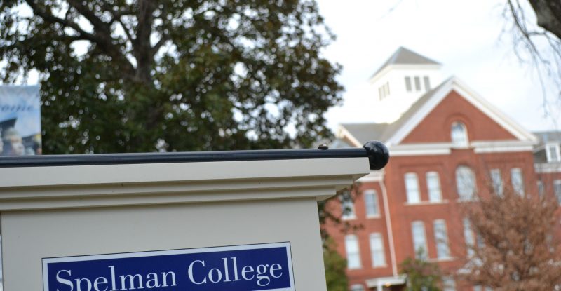 Spelman College sign with campus building in the background