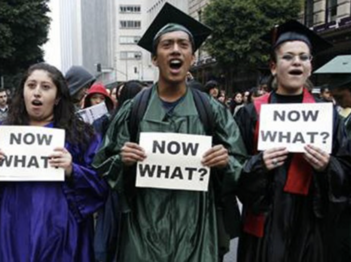 Students in graduation caps and gowns hold signs that say 