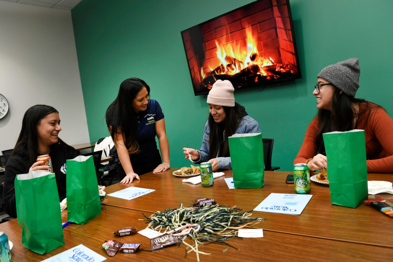 Freshman CSU students Anahi Gandara, left, Cynthia Diaz, center right, and Bianca Balderra, right, talk with Irma Venegas, center left, over snacks during a pre-finals party at Colorado State University in Fort Collins on Dec. 9, 2019. Venegas is the Director of KIPP Through College and Career program, an organization tasked with helping students who graduated from the KIPP Colorado Schools charter network with succeeding in college.