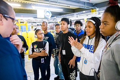 Amazon leaders and associates from the Baltimore area take the new robotics team from KIPP Ujima Village Academy on special tour of the robotics facility