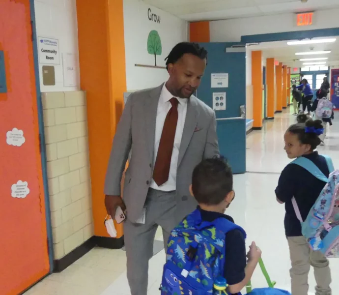 KIPP Memphis CEO Antonio Burt chats with students in a hallway.