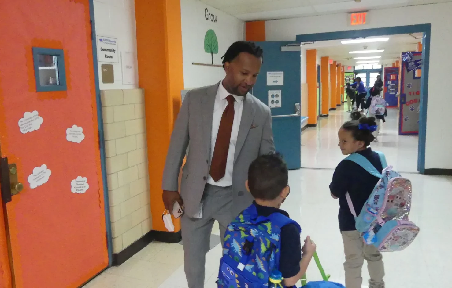 KIPP Memphis CEO Antonio Burt chats with students in a hallway.
