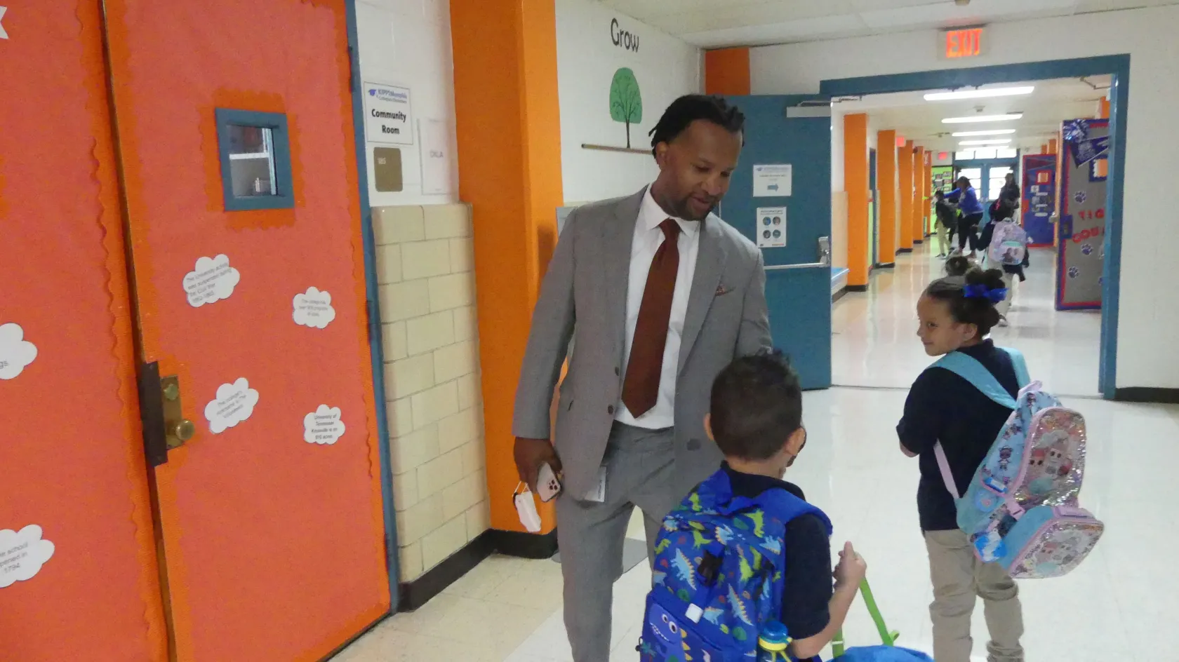 KIPP Memphis CEO Antonio Burt chats with students in a hallway.
