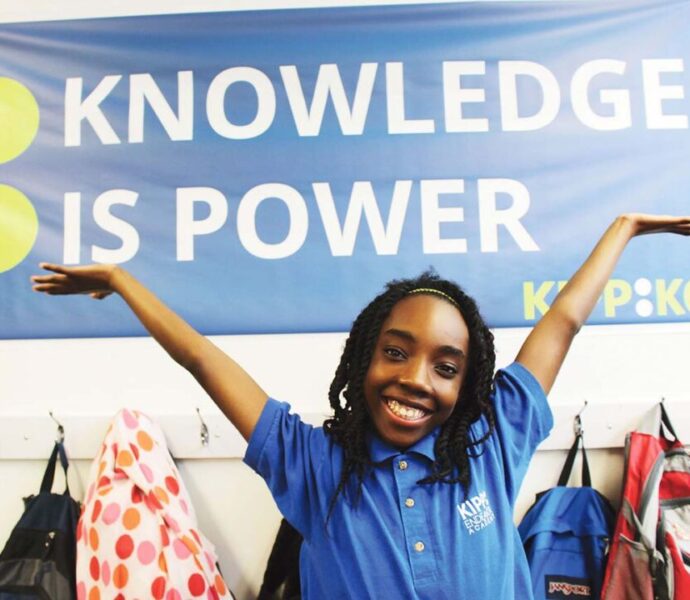 Student in Front of KIPP: KC Knowledge is Power Banner