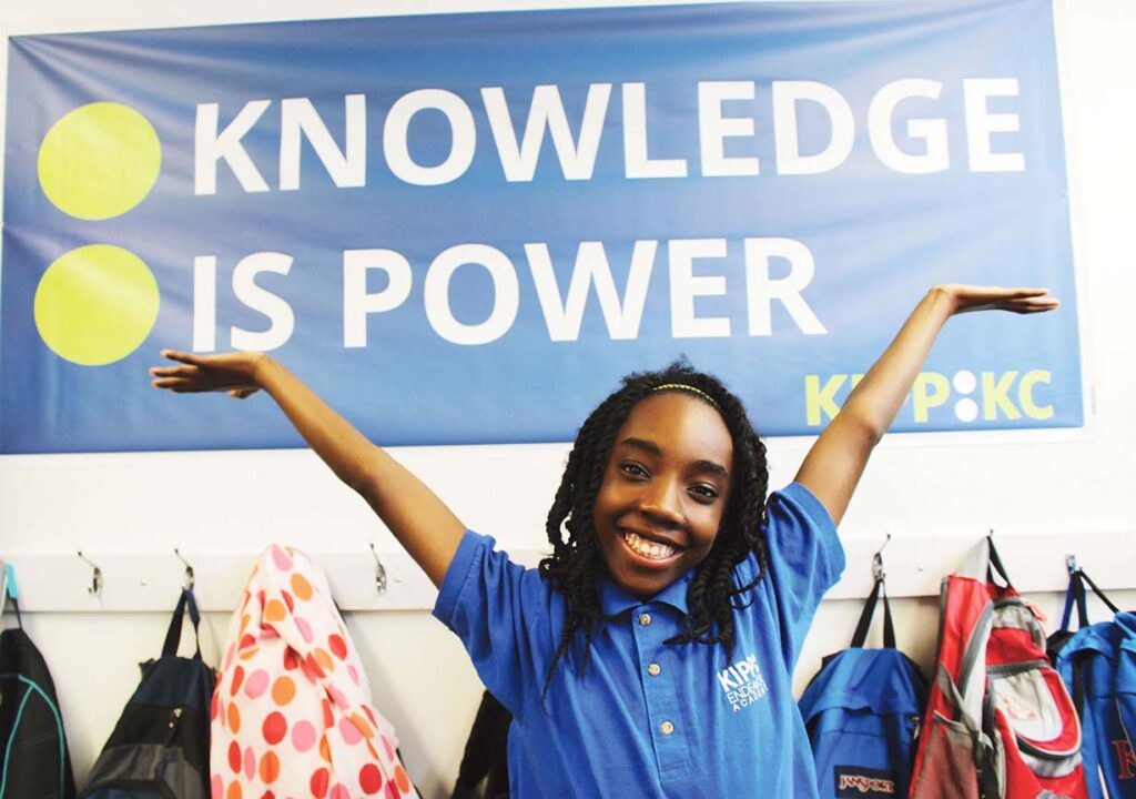 Student in Front of KIPP: KC Knowledge is Power Banner